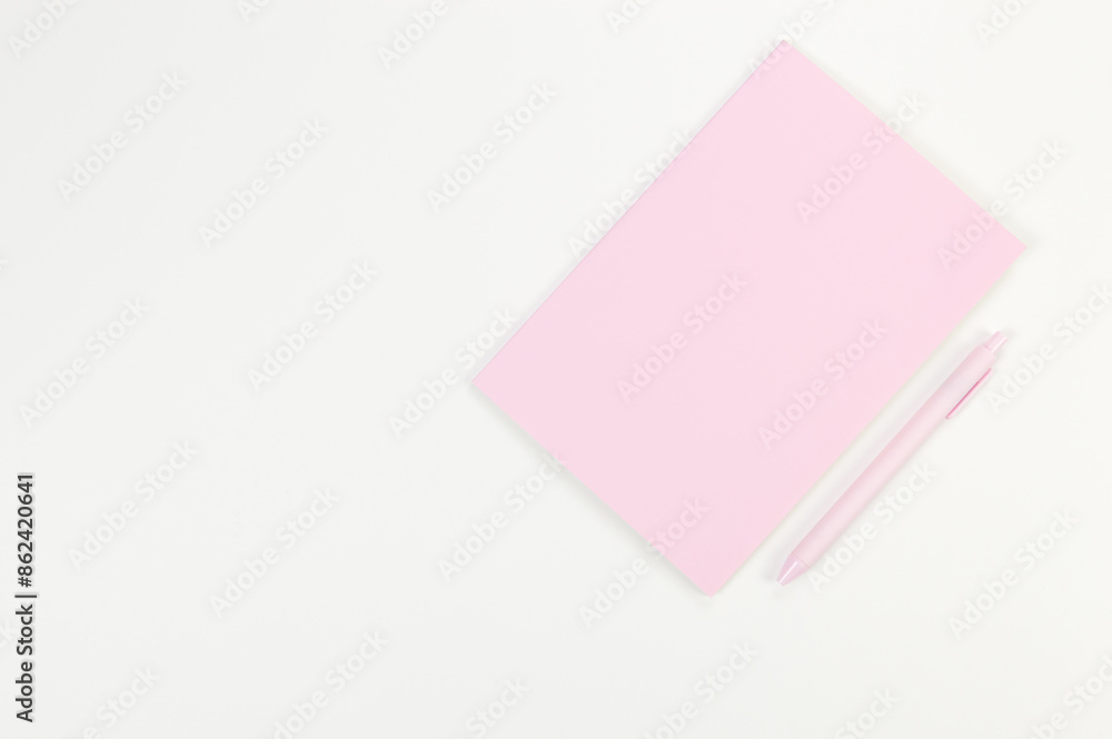 Top view of pink notebook, pink pen on white background. School, office wallpaper. Flat lay, copy space. Top view of pink notebook, pink pen on white background. School, office wallpaper. Flat lay, copy space.