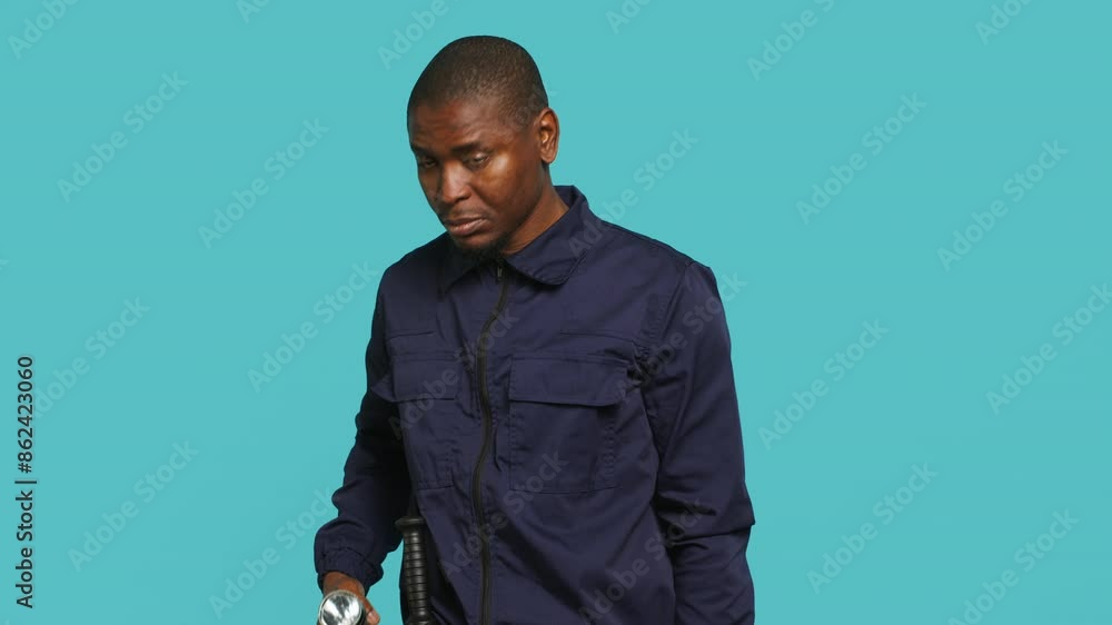 Security guard turning on flashlight, being tasked with preventing criminal activity and detaining suspects performing crimes. Portrait of bodyguard using lantern device, studio background, camera A Security guard turning on flashlight, being tasked with preventing criminal activity and detaining suspects performing crimes. Portrait of bodyguard using lantern device, studio background, camera A