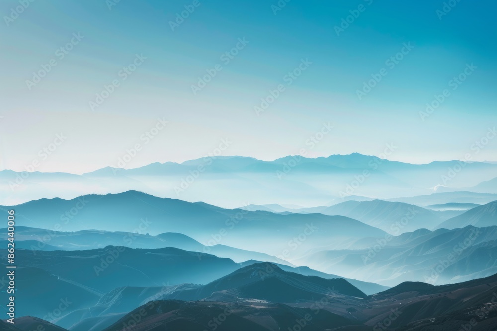 A breathtaking view of a distant mountain range with layered peaks under a clear sky, showcasing natural beauty and serene landscapes