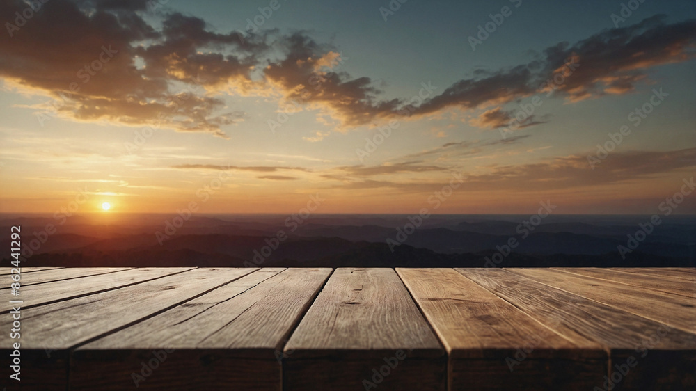 A wooden table with a view of the mountains and a sunset in the background