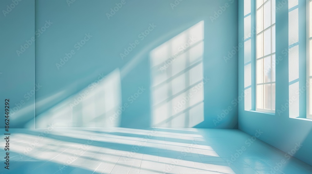 Obraz premium An empty room filled with sunlight streaming through large windows, casting geometric shadows on the floor.