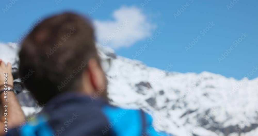 Rack focus between back of man's head and snowy mountain peak Rack focus between back of man's head and snowy mountain peak