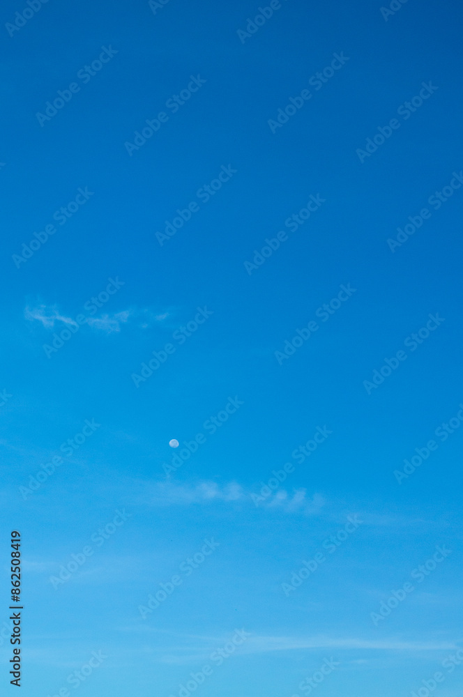 the sky is clear blue and the moon looks small the sky is clear blue and the moon looks small