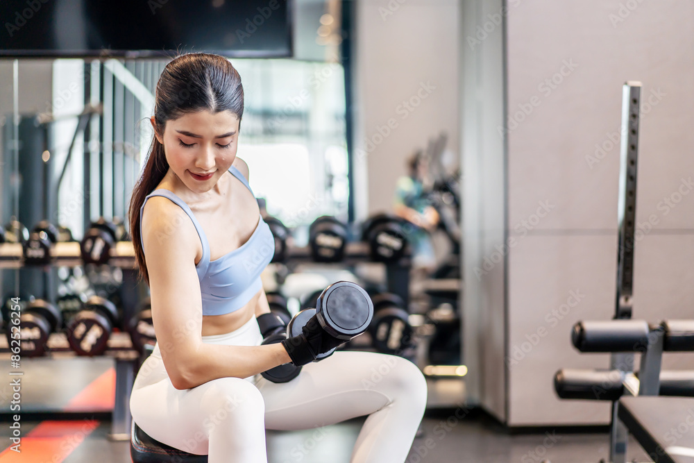 Weights training, Young asian woman lifting weights with equipment in the background, Sport ware girl workout with strong beautiful fit body shape, Asia lifestyle with copy space Weights training, Young asian woman lifting weights with equipment in the background, Sport ware girl workout with strong beautiful fit body shape, Asia lifestyle with copy space