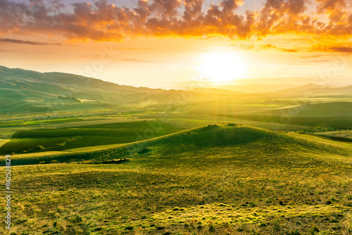 rustic landscape with summer or autumn farm field after crop harvesting. Farmland in countryside with green and yellow fields and beautiful clousy sky on background photo