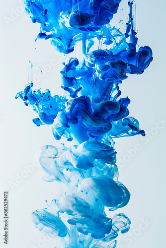 Blue and white ink swirling in water creating abstract shapes and forms