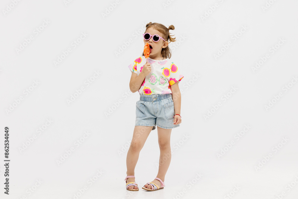 Happy little cute girl with a lollipop on a white background. Happy child enjoying childhood. Happy little cute girl with a lollipop on a white background. Happy child enjoying childhood.
