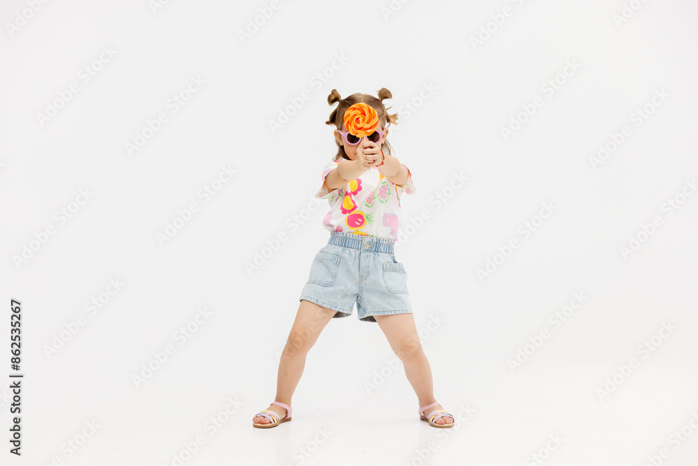 Happy little cute girl with a lollipop on a white background. Happy child enjoying childhood. Happy little cute girl with a lollipop on a white background. Happy child enjoying childhood.