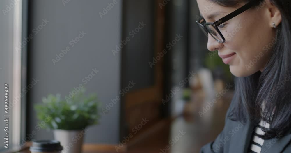 Close-up tilt-down portrait of young businesswoman typing with laptop computer at table in cafe. Modern technology and professional occupation concept. Close-up tilt-down portrait of young businesswoman typing with laptop computer at table in cafe. Modern technology and professional occupation concept.