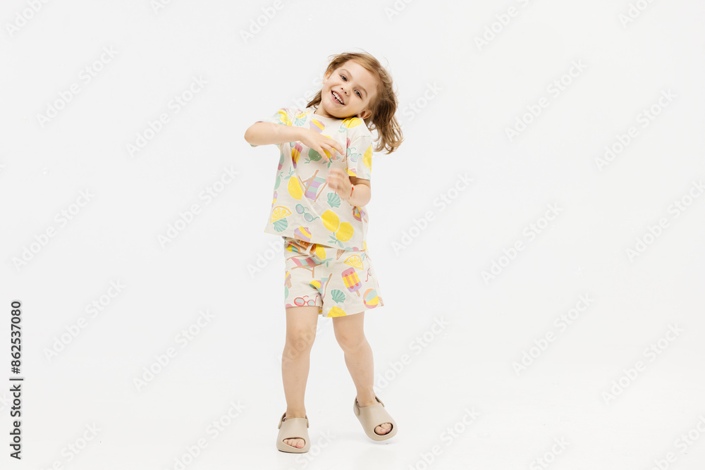 Little girl dancing in the studio on a white background. Happy energetic girl having fun and enjoying her childhood. Concept of fashion, style and happy children's emotions. Little girl dancing in the studio on a white background. Happy energetic girl having fun and enjoying her childhood. Concept of fashion, style and happy children's emotions.
