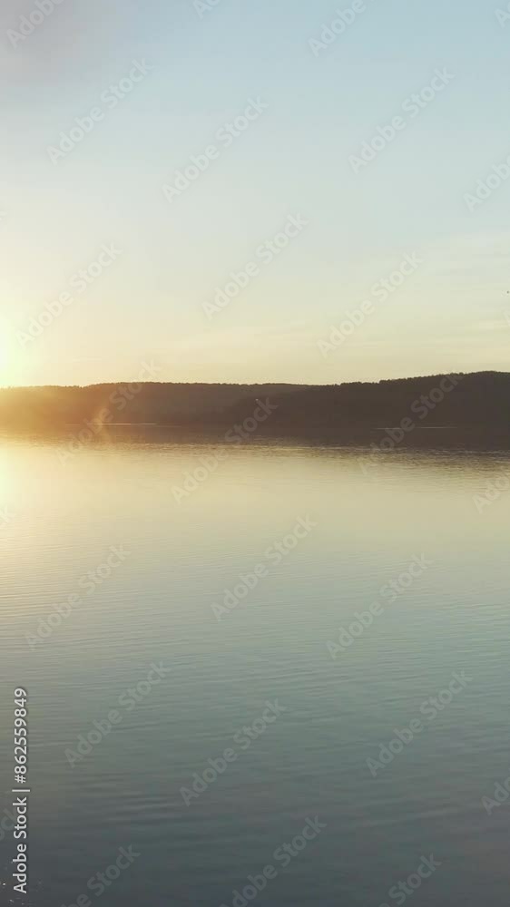 Golden hour, view of the lake in the national park at sunset, forest landscape on the horizon, vertical video, natural background. Golden hour, view of the lake in the national park at sunset, forest landscape on the horizon, vertical video, natural background.