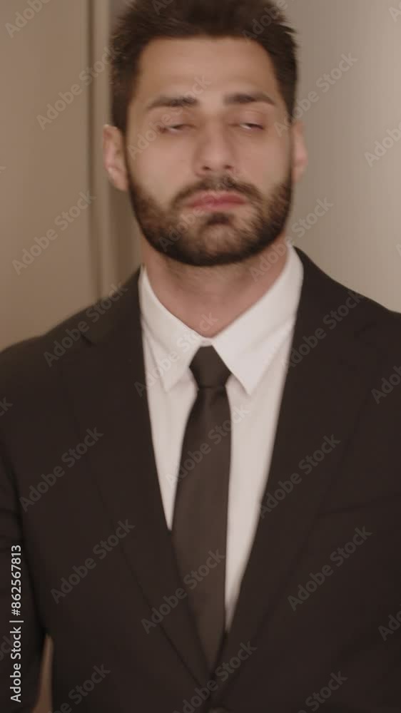 Vertical tracking front view medium shot of serious well-dressed Middle Eastern businessman walking along hallway in luxurious hotel Vertical tracking front view medium shot of serious well-dressed Middle Eastern businessman walking along hallway in luxurious hotel
