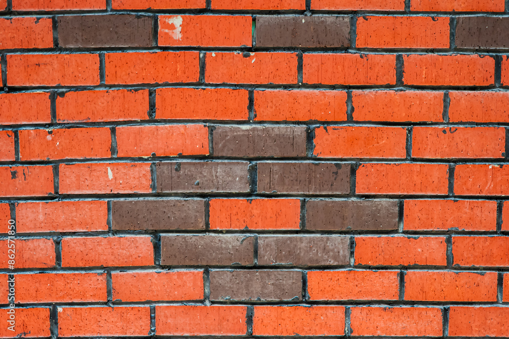 Obraz premium Close up of a brick wall with a unique pattern of orange and brown bricks, texture, background.