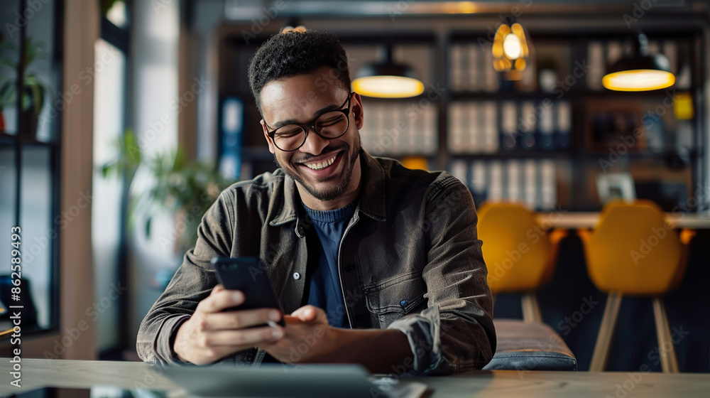 Photo of a smiling man using a mobile phone while being at the office Photo of a smiling man using a mobile phone while being at the office