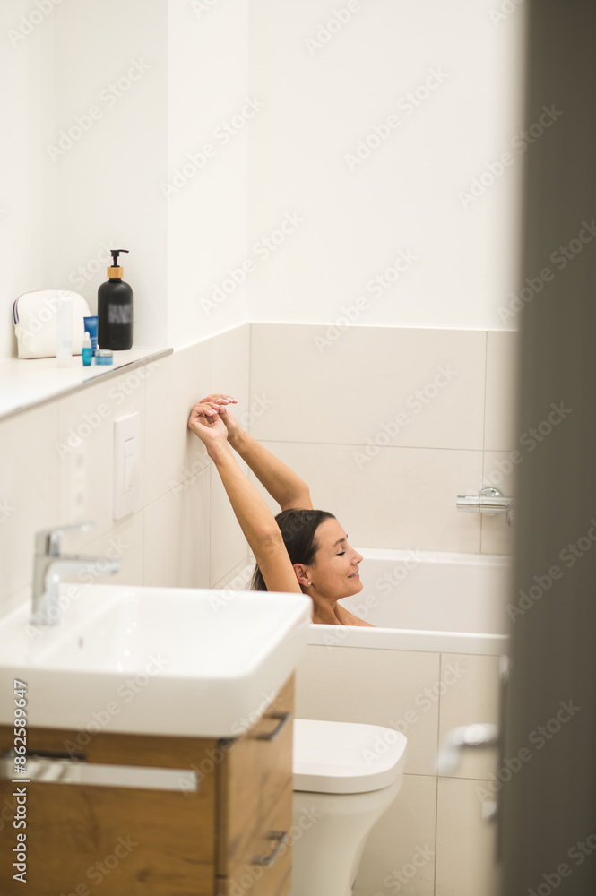 Obraz premium Dark-haired woman feeling relaxed in the bathroom