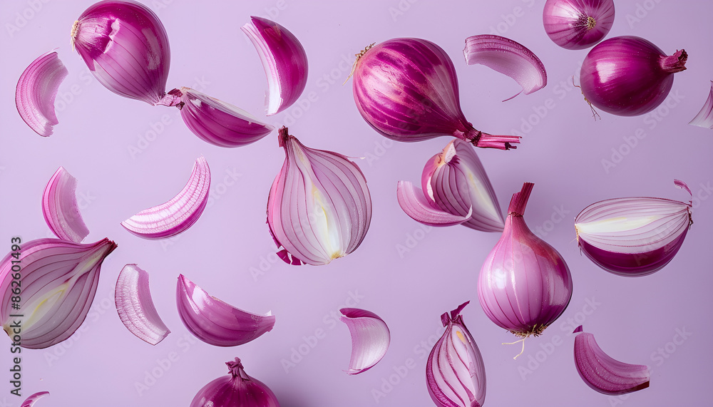 Whole and cut fresh red onions falling on light violet background Whole and cut fresh red onions falling on light violet background