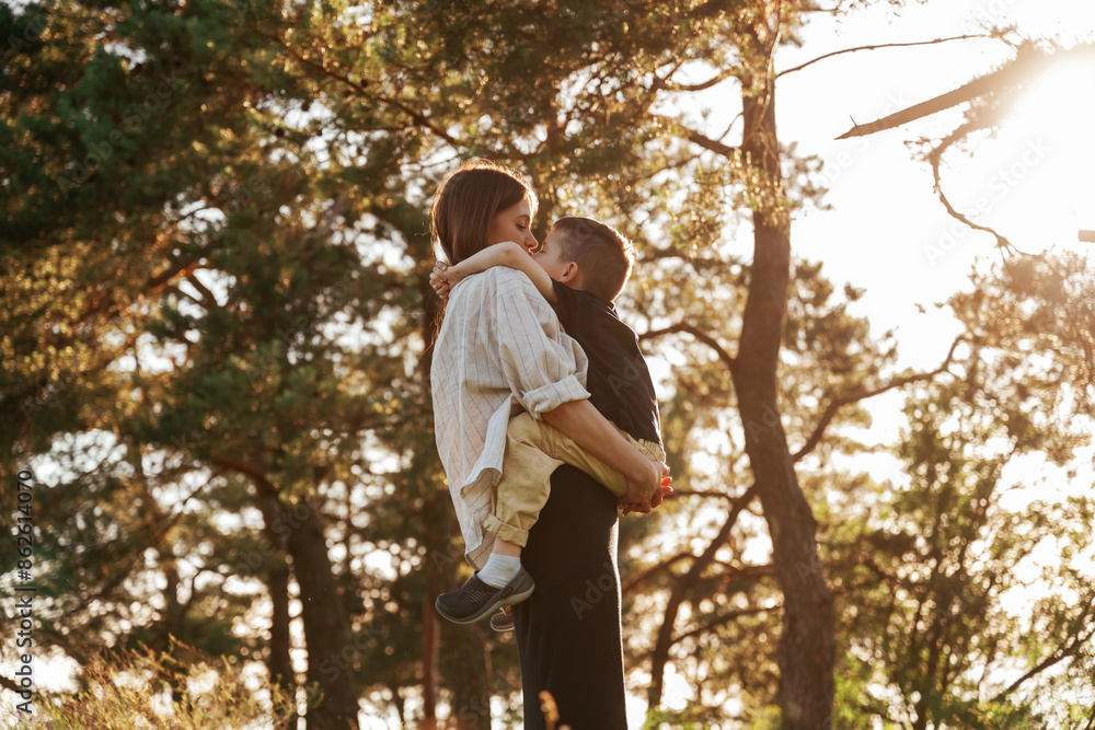 Enjoying the time together. Mother and son are in the forest Enjoying the time together. Mother and son are in the forest