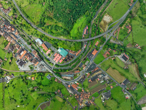 Aerial view of village with homes, roads, fields, and trees in greenery, Infiesto, Asturia, Spain. photo