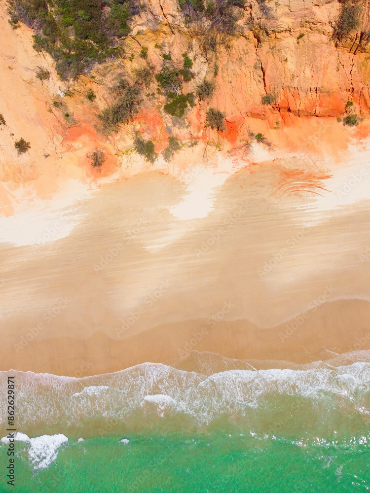 Aerial view of turquoise beach with cliffs and clear water, Rainbow Beach, Australia. Aerial view of turquoise beach with cliffs and clear water, Rainbow Beach, Australia.