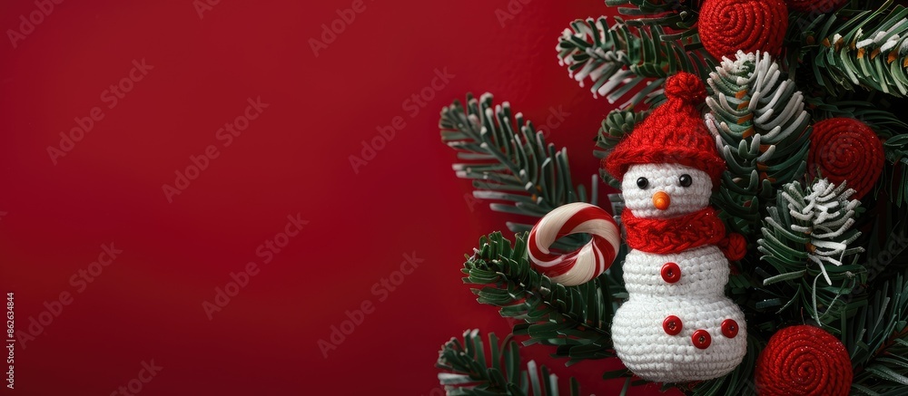 Top view photo of a small toy snowman on a Christmas tree with crochet candy lollipop on red background, symbolizing New Year and winter holidays. Flat lay card with copy space image. Top view photo of a small toy snowman on a Christmas tree with crochet candy lollipop on red background, symbolizing New Year and winter holidays. Flat lay card with copy space image.