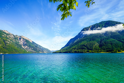 View of Lake Achensee in Tyrol. Nature at the turquoise lake and a mountain landscape in the background. Achental in Austria. 