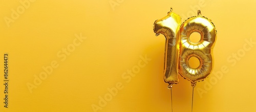 Elegant gold foil balloon shaped like the number 18 on a birthday card with the inscription 18 for an anniversary celebration, set against a glittering, bright gold numeral on a yellow background photo
