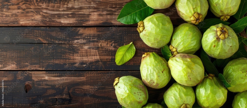 Top view of ripe green guavas displayed on a rustic wooden surface with copy space image. Top view of ripe green guavas displayed on a rustic wooden surface with copy space image.