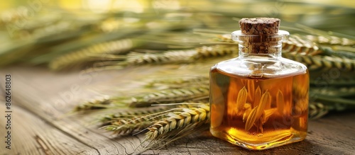 A glass bottle featuring essence made from wheat, barley, rye, and oats displayed on a wooden surface with green wheat ears, ideal for cosmetic product ads needing a copy space image.