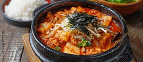 Korean hot pot with kimchi, rice, and Gim seaweed, presenting a delightful culinary composition in a single dish, perfect for sharing in a cozy setting with a background of a copy space image. photo