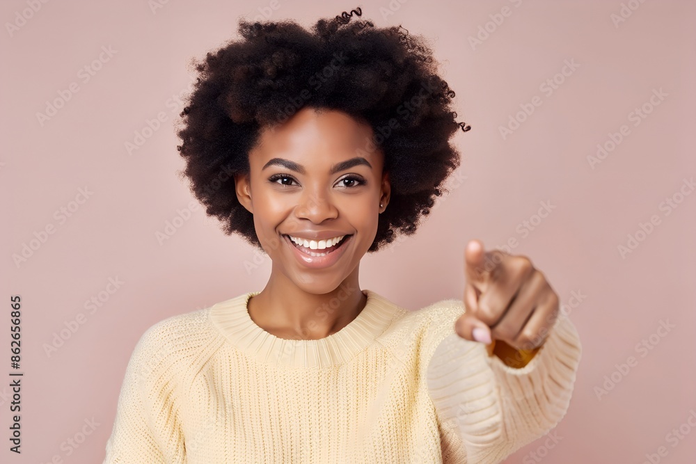 Cheerful Afro woman points away on copy space, discusses amazing promo, gives way or direction, wears warm sweater, has pleasant smile, feels optimistic, isolated over neutral background Cheerful Afro woman points away on copy space, discusses amazing promo, gives way or direction, wears warm sweater, has pleasant smile, feels optimistic, isolated over neutral background