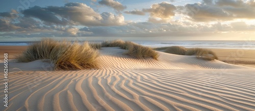 A stunning scene with intricate patterns on the sand dunes captured in a copy space image near the marram grass on Formby beach.