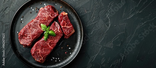 Top view of a plate with garnished Striploin or New York beef steaks on a black background, with ample copy space image. photo