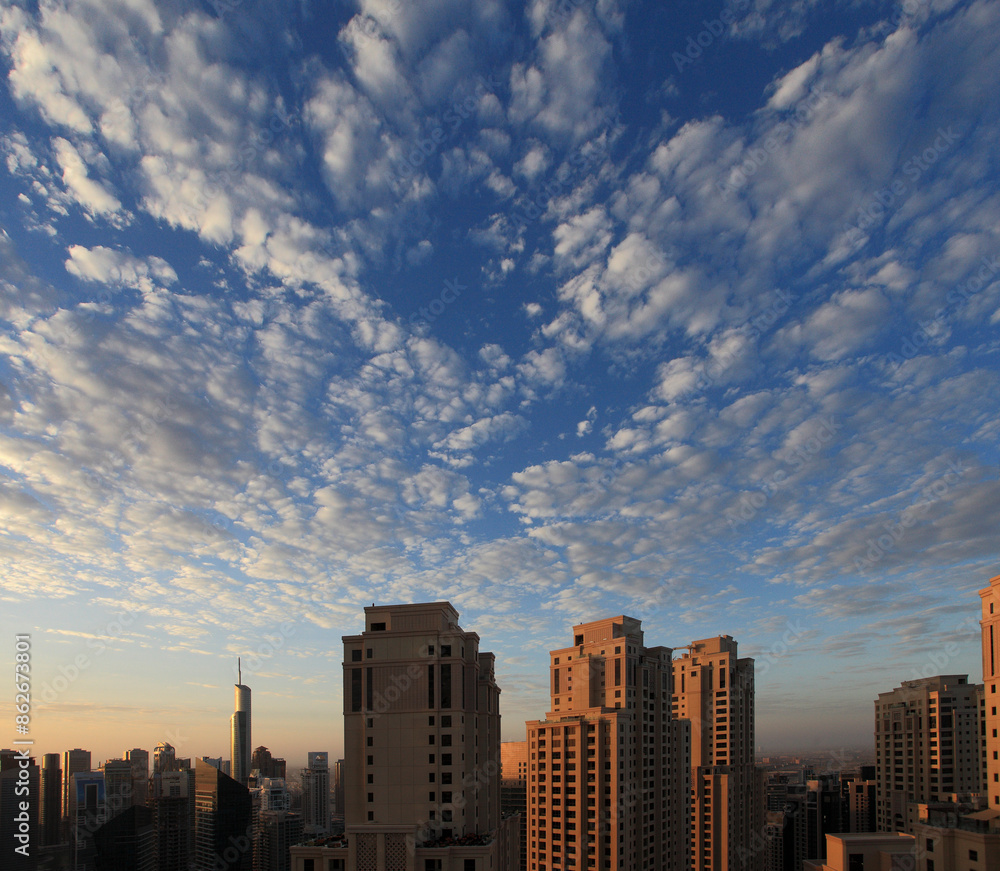 View of modern city skyline at sunset with cloudy sky, Dubai, United Arab Emirates. View of modern city skyline at sunset with cloudy sky, Dubai, United Arab Emirates.
