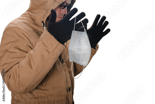 Man removing his medical mask after end of epidemic, Safety first: Isolated shot of a man's face with a protective mask