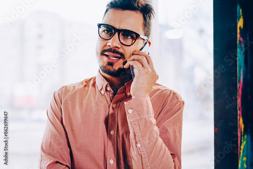 Εκτύπωση καμβά Male businessman making dissatisfied face while talking with service operator on