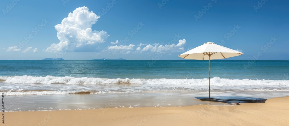 Beach scene with umbrella on sandy shore, offering a serene view with ample copy space image. Beach scene with umbrella on sandy shore, offering a serene view with ample copy space image.