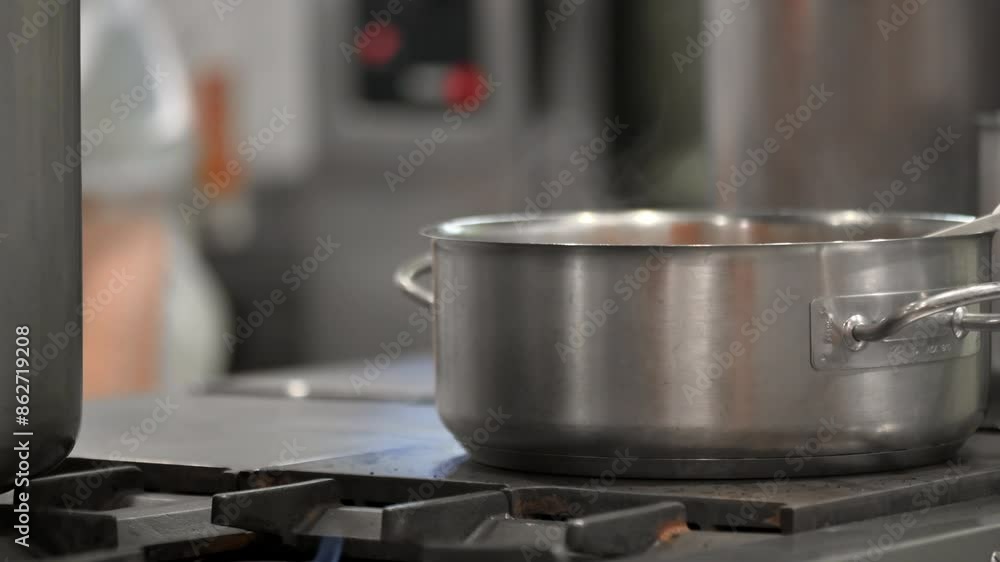 Close up view of casseroles at a commercial kitchen. Preparing and cooking food in a commercial kitchen. Unrecognizable Chefs in the background. High quality 4k footage Close up view of casseroles at a commercial kitchen. Preparing and cooking food in a commercial kitchen. Unrecognizable Chefs in the background. High quality 4k footage