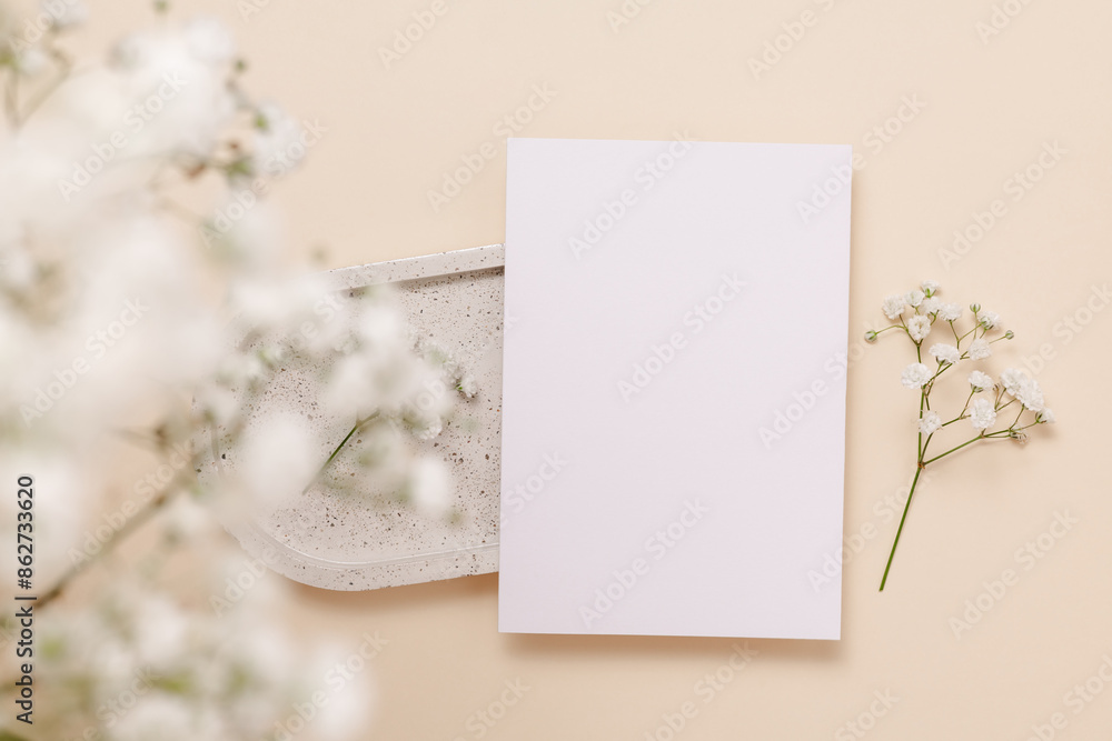 Gentle paper card on ceramic tray with white gypsophila flowers on beige background, top view. Mockup paper card for design, print, wedding and invitation, aesthetic style Gentle paper card on ceramic tray with white gypsophila flowers on beige background, top view. Mockup paper card for design, print, wedding and invitation, aesthetic style