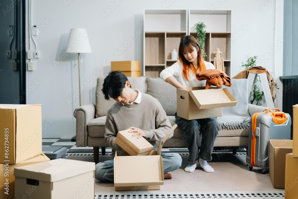 Young couple with big boxes moving into a new house, new apartment for couple, young asian man and woman helping to lift boxes on sofa for Young couple with big boxes moving into a new house, new apartment for couple, young asian man and woman helping to lift boxes on sofa for