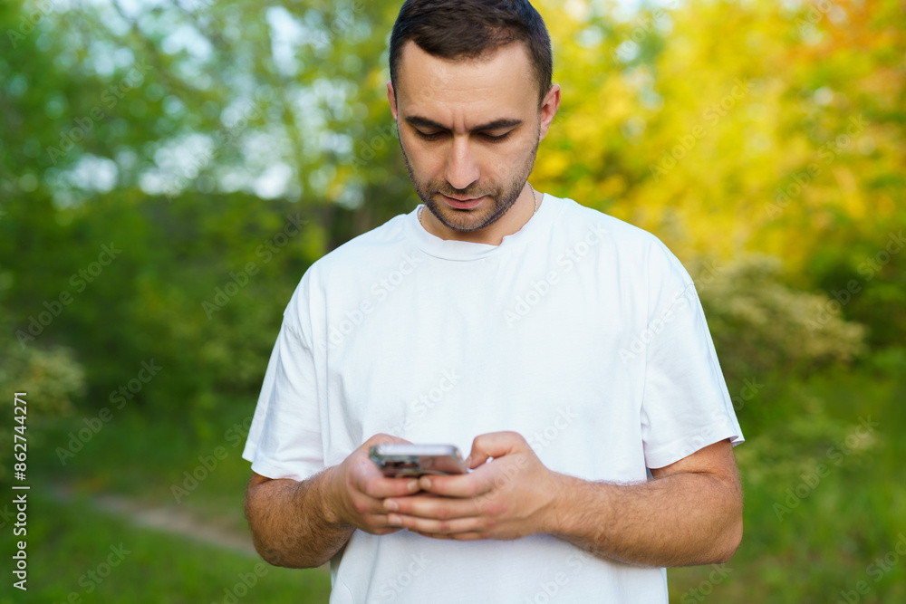 Picture of bearded man, browsing the internet on his phone enjoying a lovely day outside. Picture of bearded man, browsing the internet on his phone enjoying a lovely day outside.