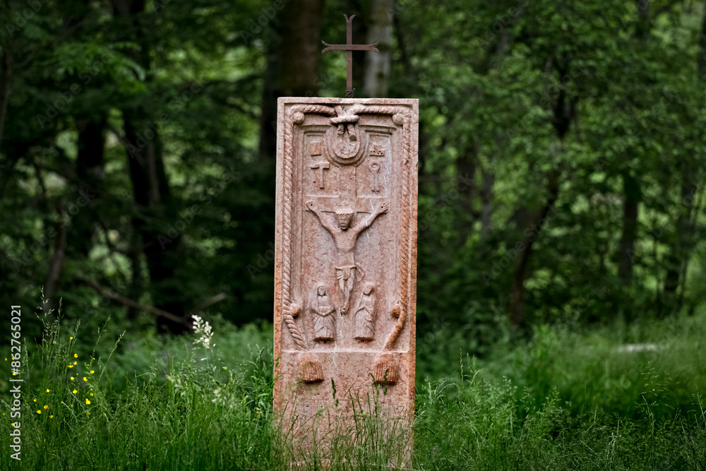 Ancient folk sculpture of the crucifixion of Jesus Christ in the middle of the wood. Contrada Covel, Velo Veronese, Lessinia, Veneto, Italy.