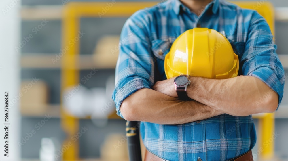 A man wearing a yellow hard hat and a blue plaid shirt A man wearing a yellow hard hat and a blue plaid shirt