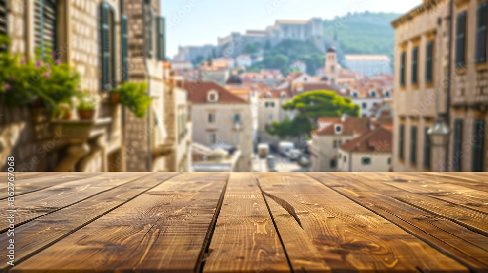 Fototapeta premium Wooden table top with blurred European old town view in background.