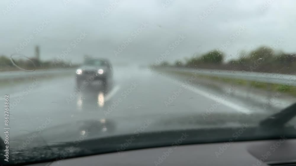Point-of-view perspective of driving in heavy rain on a highway during a rainstorm. Point-of-view perspective of driving in heavy rain on a highway during a rainstorm.