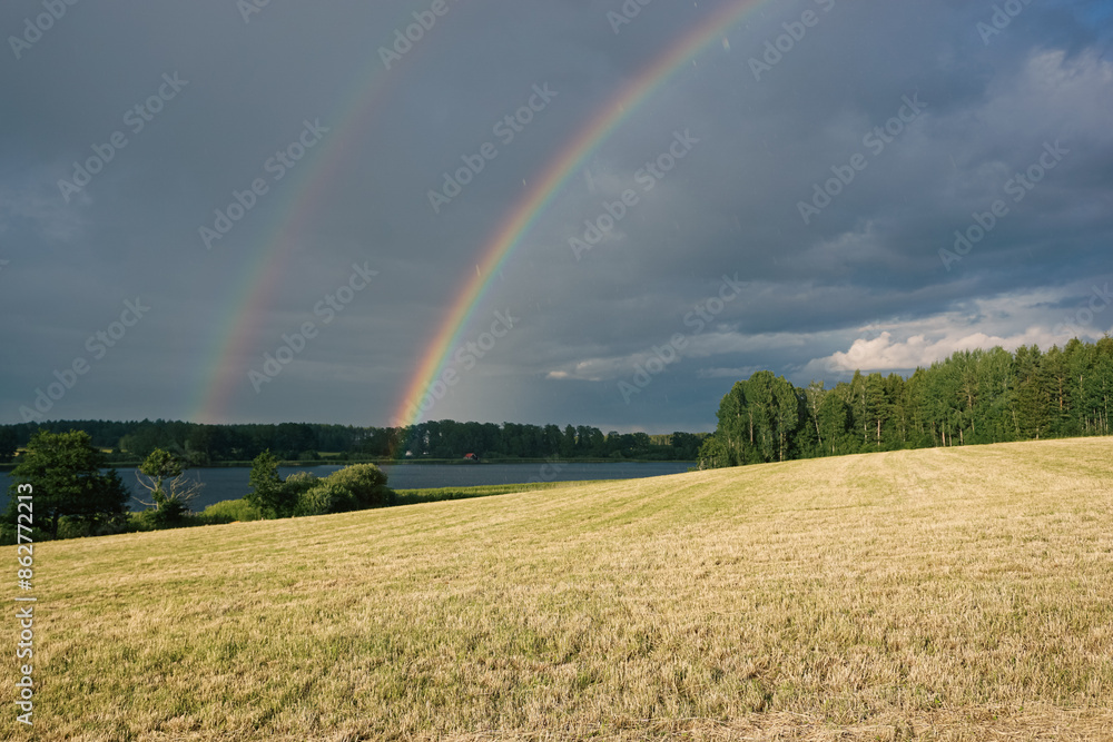 A rainbow over field during summer A rainbow over field during summer