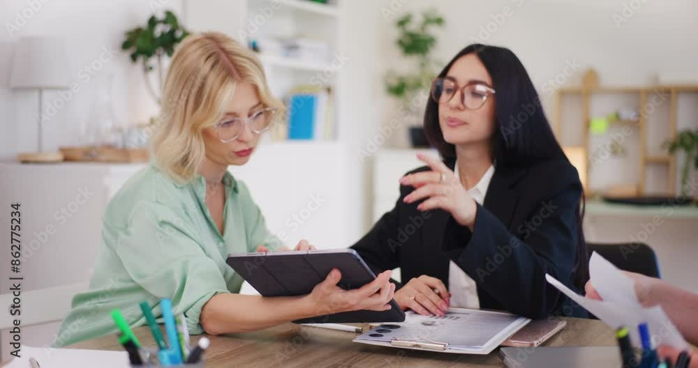 Women Discuss Project on Digital Tablet in Office Women Discuss Project on Digital Tablet in Office