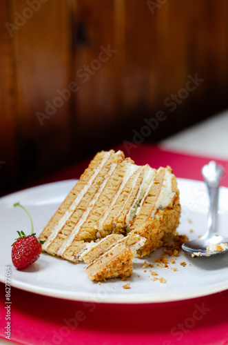Slice Crepe cake Medovik with sour cream vanilla cream and strawberries. Slice Pancake cake Medovik decorated with strawberries.