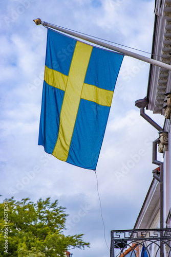 Sweden flag waving in cloudy sky. Yellow blue Flag of Sweden flying in the sky. The national flag of Sweden, flying on a flagstaff against a blue sky on a sunny day. Close up. Copy space. photo