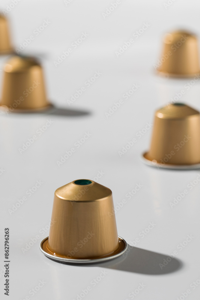 The golden coffee capsules on a white background, for advertising and commercial use. Copy space The golden coffee capsules on a white background, for advertising and commercial use. Copy space