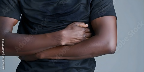 Person clutching stomach in pain indicating stomachache or digestive discomfort. Concept Stomachache, Digestive Discomfort, Painful Expression, Health Problem, Medical Emergency